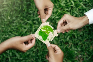hands forming an earth puzzle